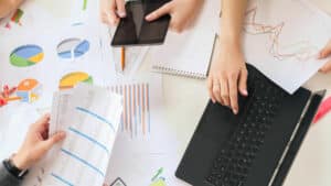 Imagem mostra um grupo de pessoas estudando e analisando gráficos