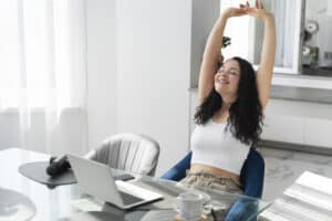Mulher se espreguiçando durante pausa nos estudos em casa