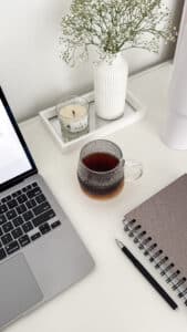 Mesa de estudo com notebook, xícara de café e flores